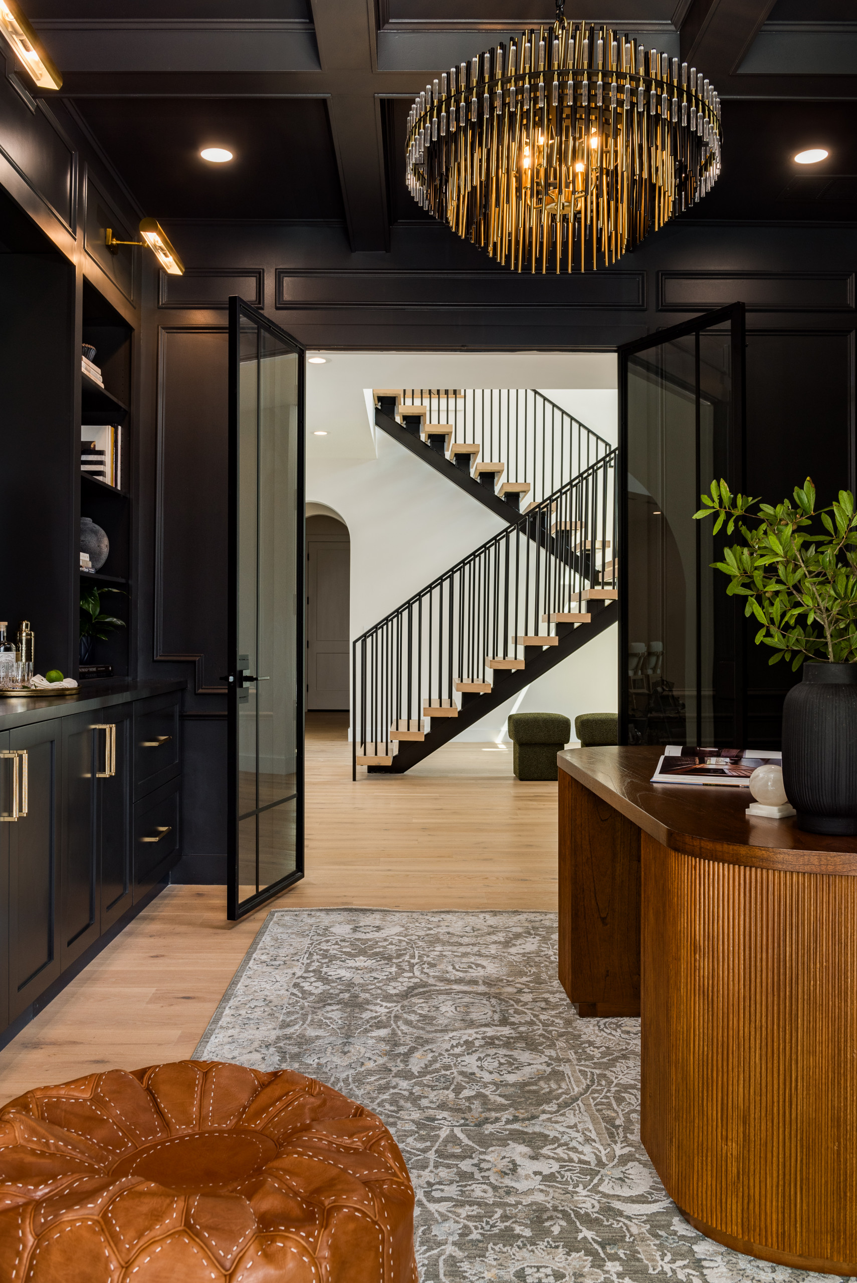 Richly paneled office with statement lighting and warm natural wood details